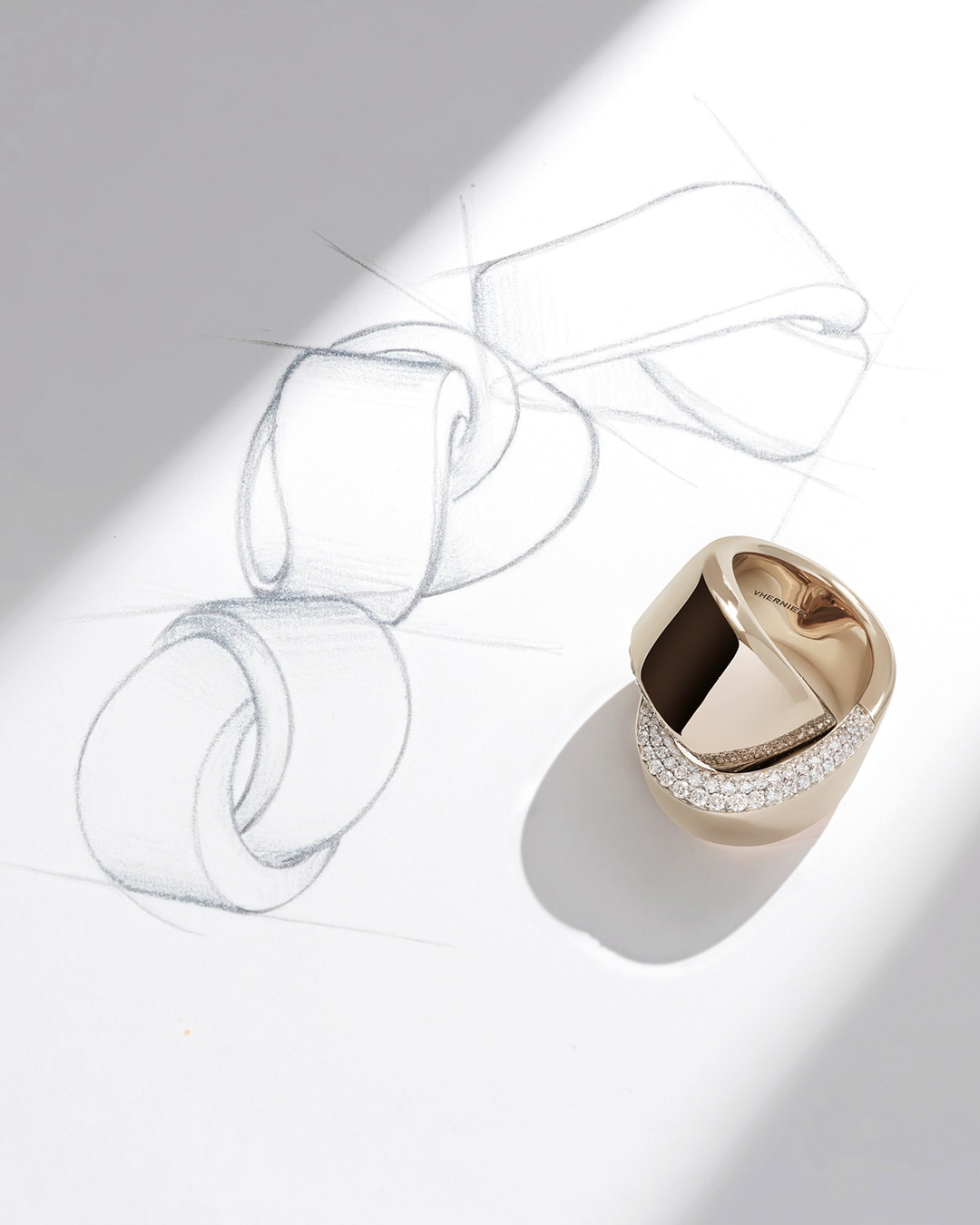 Vhernier Abbraccio ring encrusted with diamonds, with a sketch in the background
