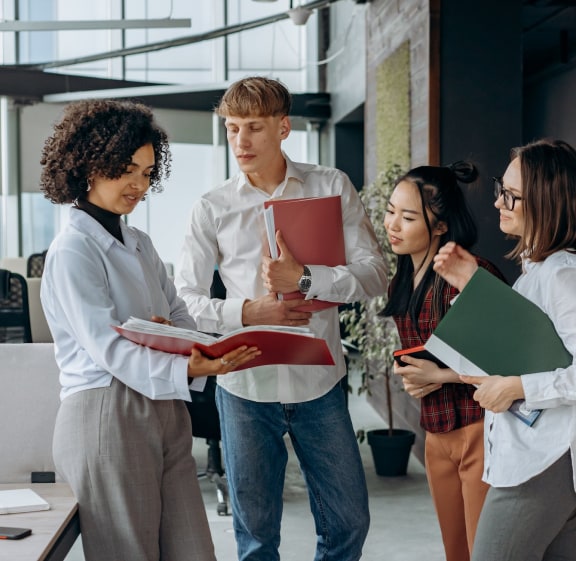 A group of workers reviewing print materials in the office