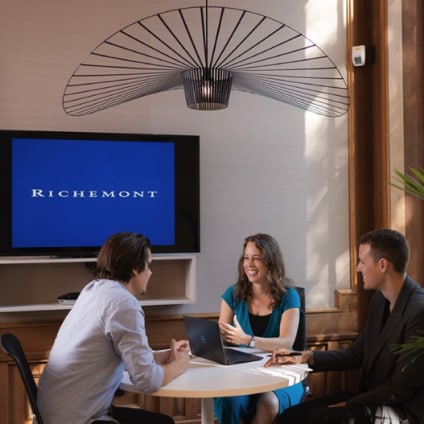 Three persons are having a casual business meeting in a conference room