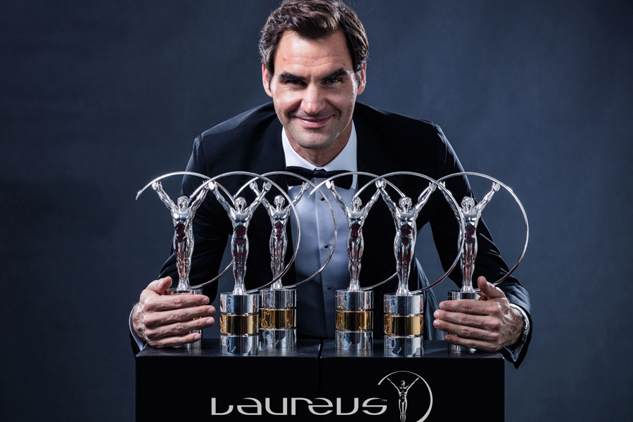 Roger Federer, a famous Swiss tennis player, holding the trophies for the Laureus sportsmen