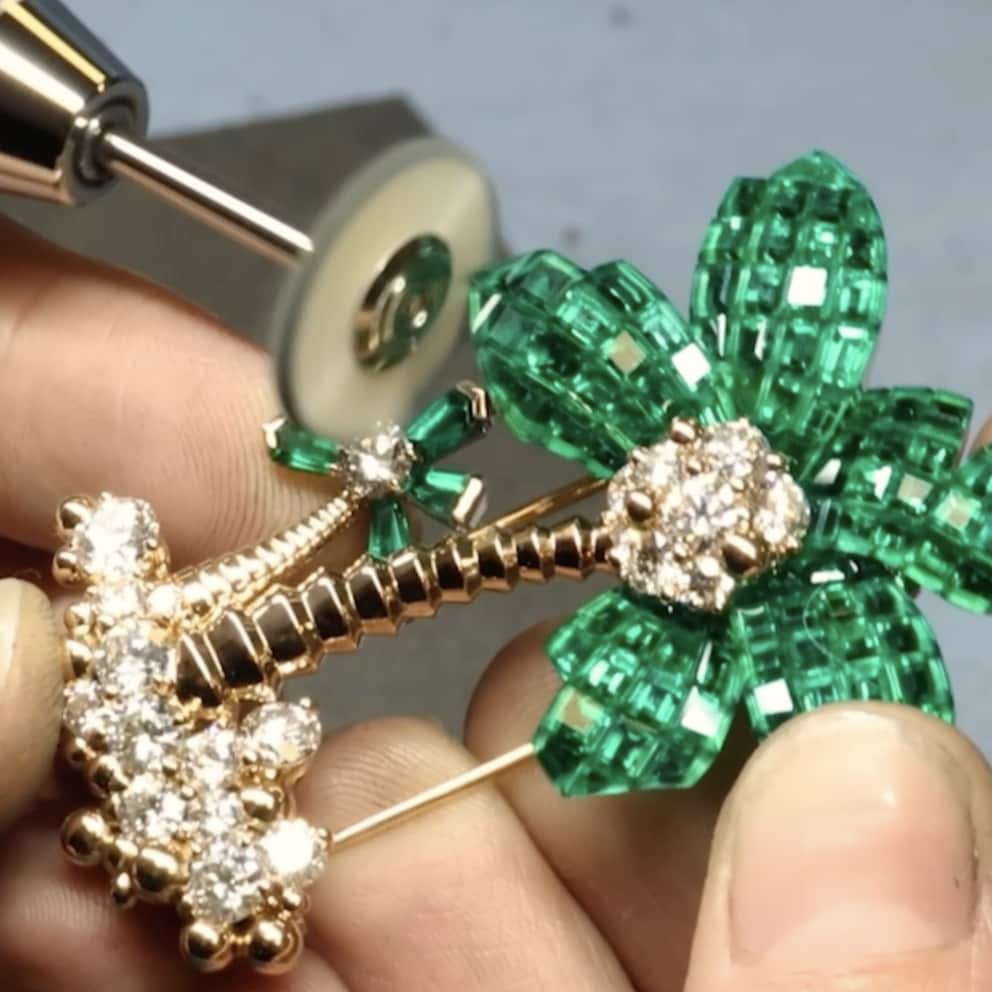 Van Cleef & Arpels artisan hands working on a jewellery palmier piece with Emeralds 