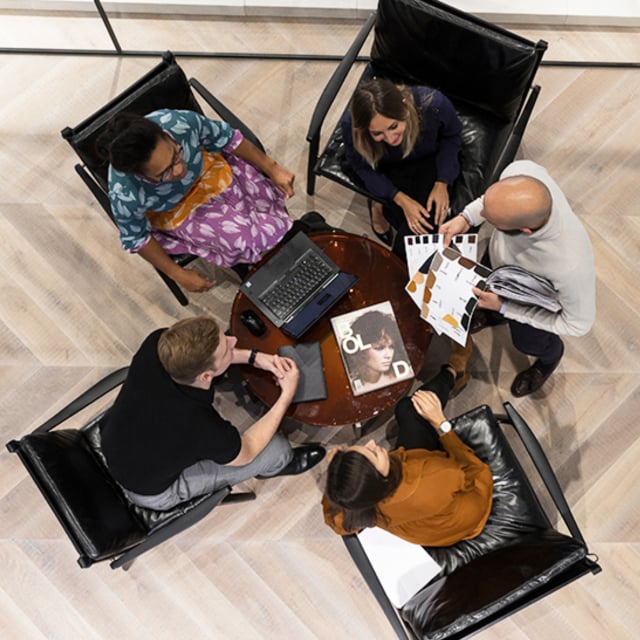 A group of workers at a coffee table having a casual business meeting