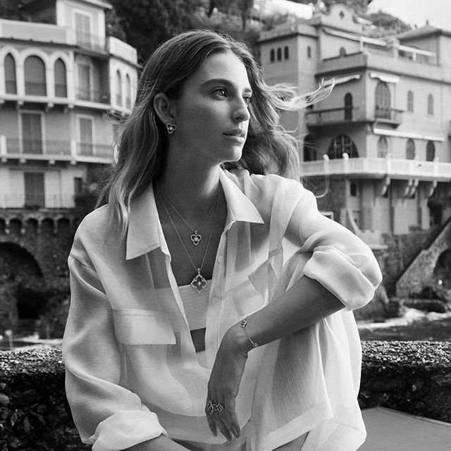 Woman model with a white outfit posing and wearing Buccellati jewels
