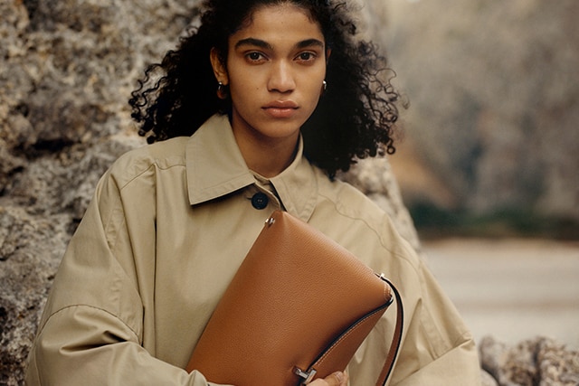 Female model holding a brown handbag-NET-A-PORTER