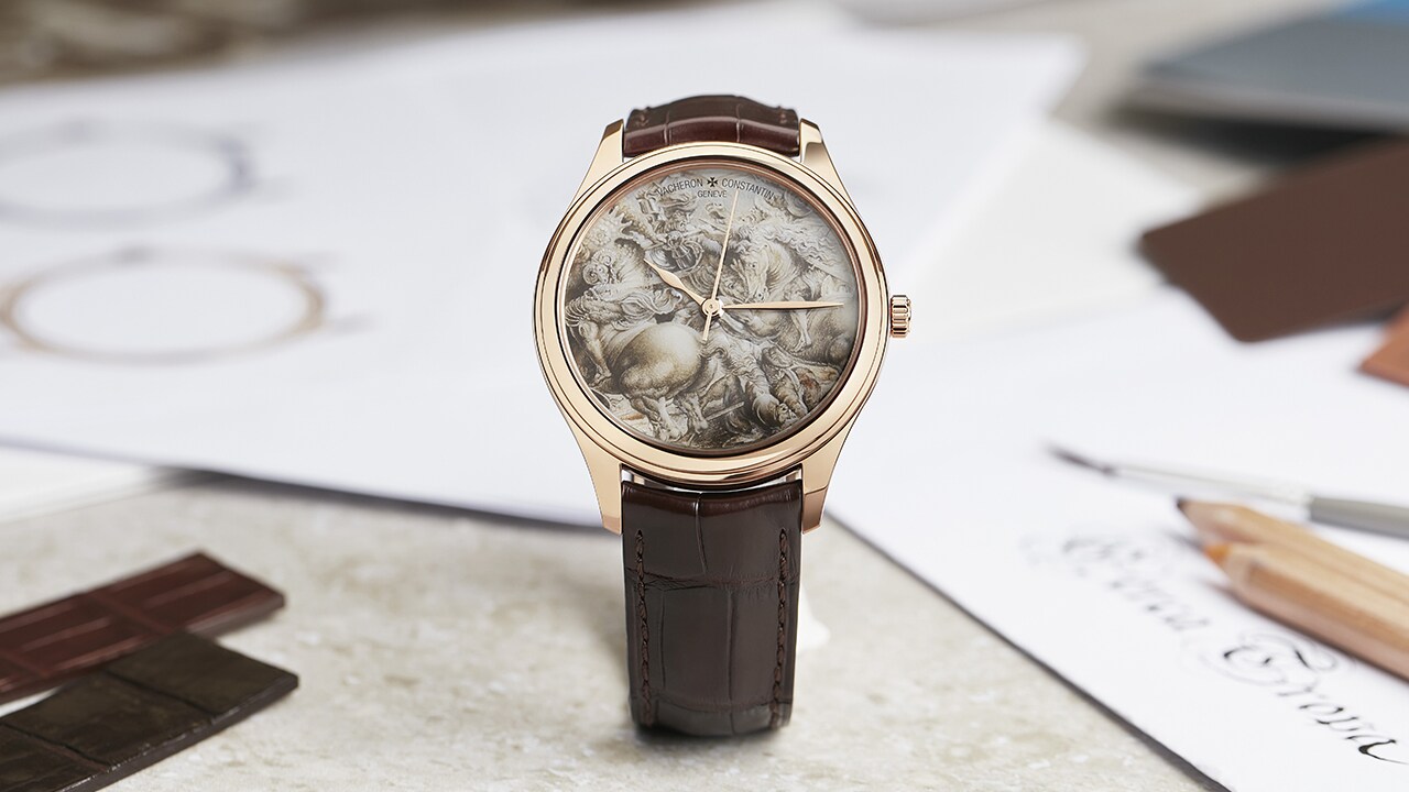 A watch on a table, with sketches in the background