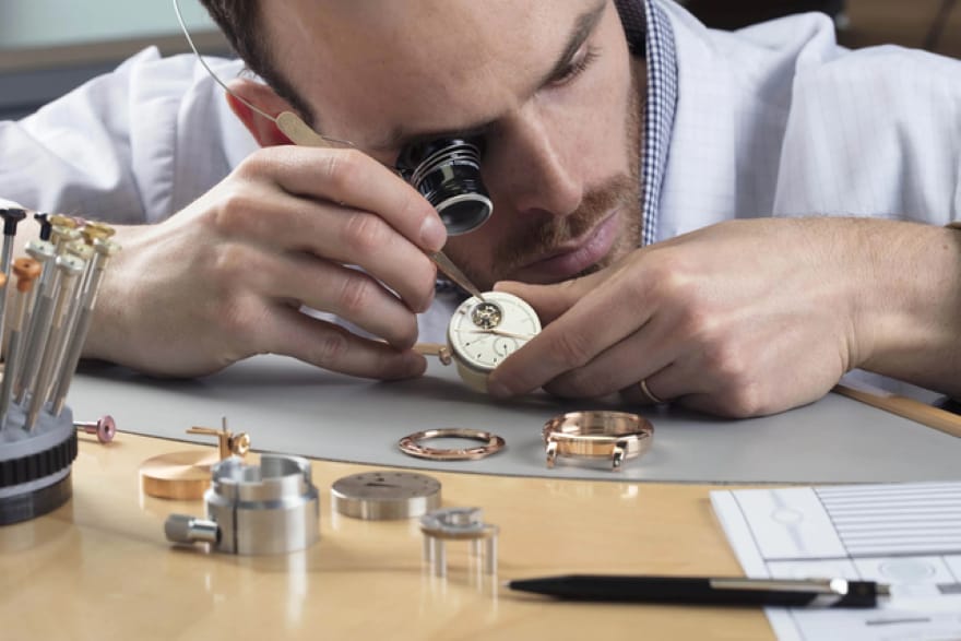 A watchmaker examining a mechanical watch