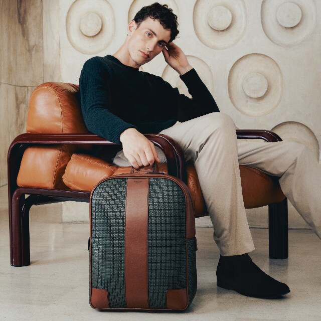 White man sitting on a chair with a big Serapian bag