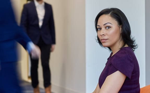 A portrait of a woman sitting in the office lobby